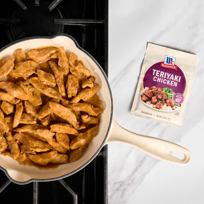 A pan of cooked teriyaki chicken strips sits next to a packet of McCormick Teriyaki Glaze.