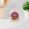 A packet of McCormick Teriyaki Chicken seasoning mix is displayed on a kitchen counter.