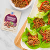 McCormick Teriyaki Chicken seasoning mix is featured next to lettuce wraps filled with teriyaki chicken and sliced bell peppers.
