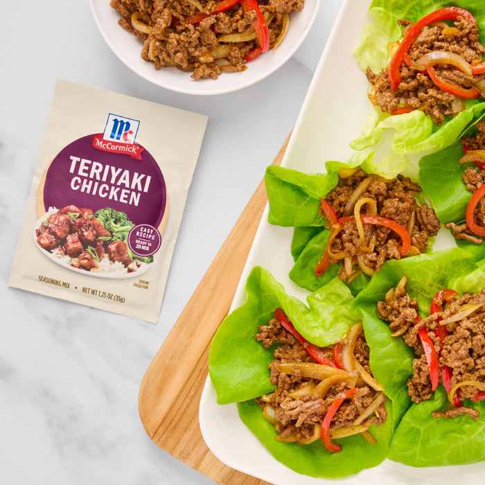 McCormick Teriyaki Chicken seasoning mix is featured next to lettuce wraps filled with teriyaki chicken and sliced bell peppers.