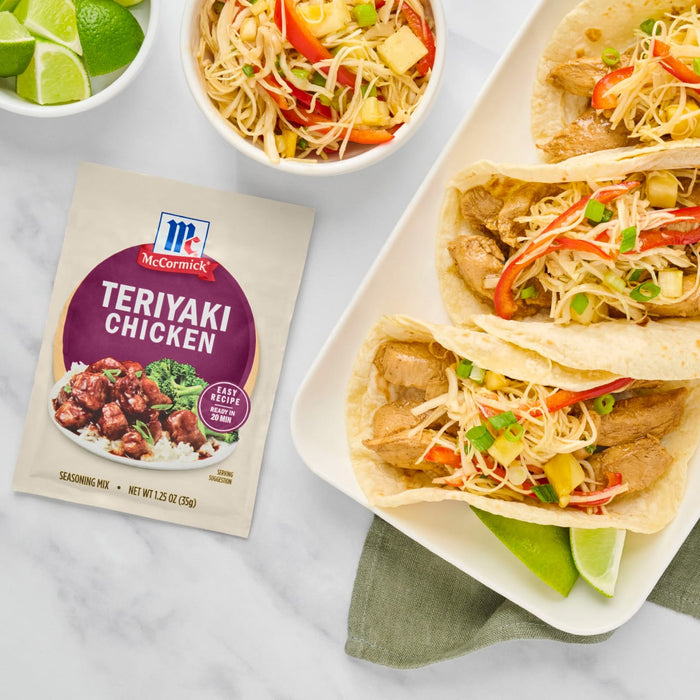 A packet of McCormick Teriyaki Chicken seasoning is displayed next to a plate of teriyaki chicken tacos with a side of rice.