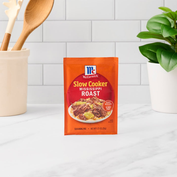 A packet of McCormick Slow Cookers Brown Gravy Roast seasoning mix sits on a kitchen counter.
