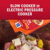 McCormick Slow Cooker Roast recipe mix being poured over beef, butter, and peppers for a slow cooker or electric pressure cooker meal.