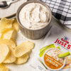 ['McCormick Just 5 Classic French Onion Dip &amp; Seasoning Mix with potato chips and a bowl of dip.']