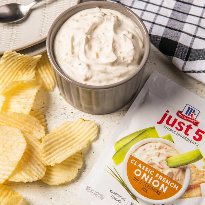 ['McCormick Just 5 Classic French Onion Dip &amp; Seasoning Mix with potato chips and a bowl of dip.']