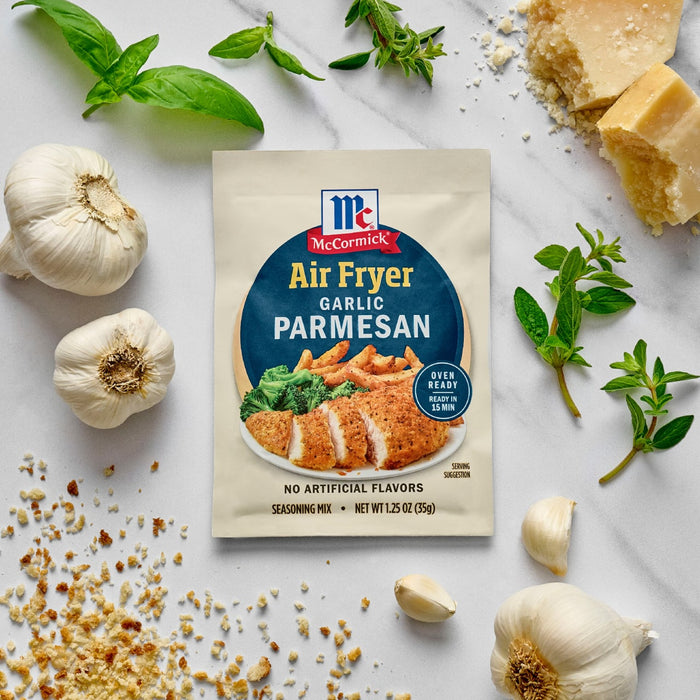 McCormick Air Fryer Garlic Parmesan seasoning packet surrounded by garlic, parmesan cheese, and herbs.