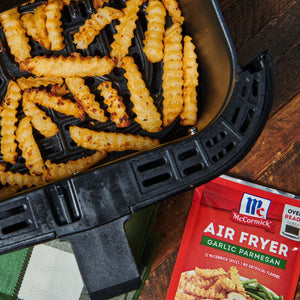 ['McCormick Air Fryer Garlic Parmesan seasoning packet with a close-up of crispy fries in an air fryer.']