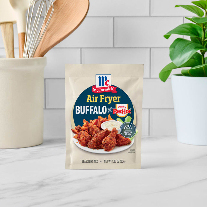 A packet of McCormick Air Fryer Buffalo Wings seasoning mix is displayed on a kitchen counter.