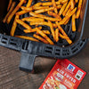 ['McCormick Air Fryer Buffalo seasoning packet next to a basket of crispy french fries in an air fryer.']