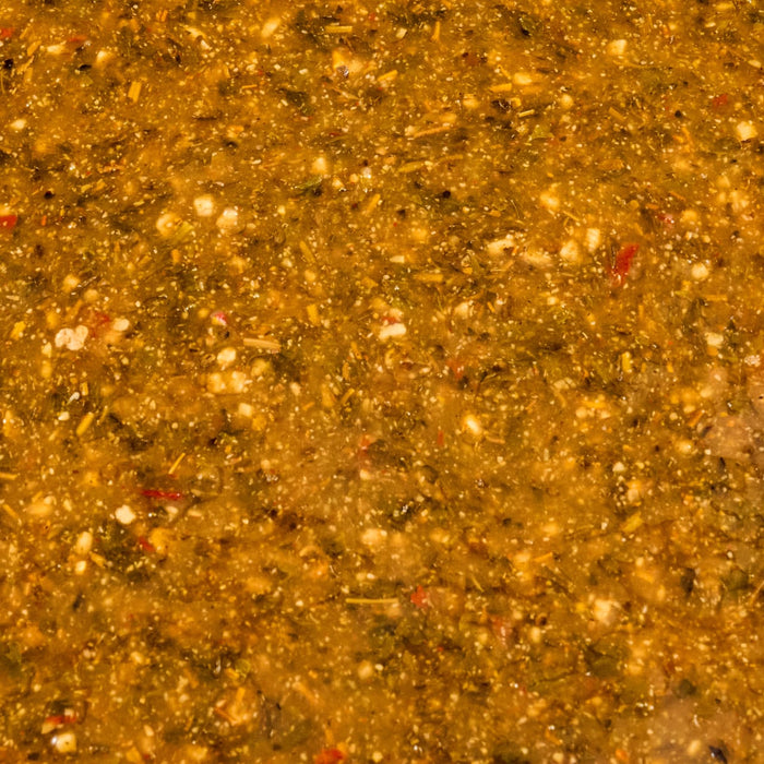 A close-up shot reveals a vibrant textured sauce with visible herbs and spices suggesting a flavorful culinary creation.