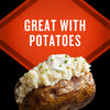 A baked potato topped with mashed potatoes, sour cream, and chives is featured in this food advertisement.