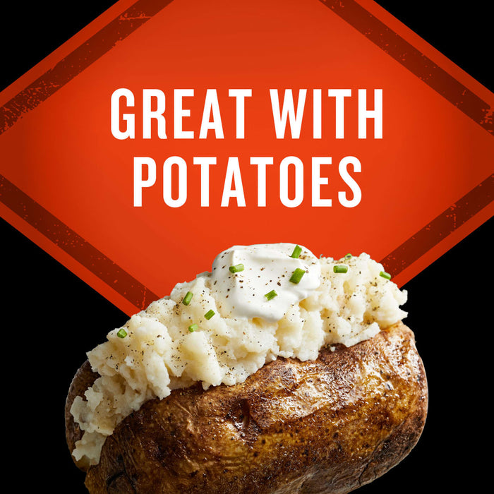 A baked potato topped with mashed potatoes, sour cream, and chives is featured in this food advertisement.
