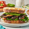 ['A sandwich with grilled mushrooms, avocado, lettuce, and tomato on toasted bread.']