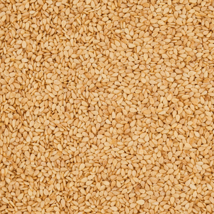 A close-up view of a pile of tan-colored sesame seeds.