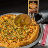 ['A pizza topped with butternut squash, basil, and a sprinkle of McCormick Grill Mates Cracked Black Pepper &amp; Garlic seasoning is being sliced with a pizza cutter.']