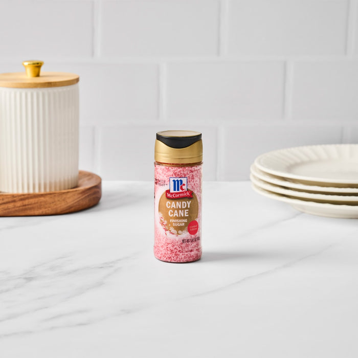 A jar of McCormick Candy Cane Seasoning is surrounded by candy canes, highlighting its sweet peppermint flavor.