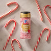 A container of McCormick Candy Cane Cinnamon Flavored Crunch Toppings is surrounded by candy canes.