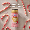 A hand sprinkles McCormick's seasonal flavor sprinkles onto a frosted dessert.