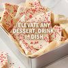 Candy bark with red sprinkles is shown in a metal tin with the text Elevate any dessert, drink, or dish.