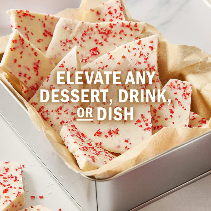 Candy bark with red sprinkles is shown in a metal tin with the text Elevate any dessert, drink, or dish.