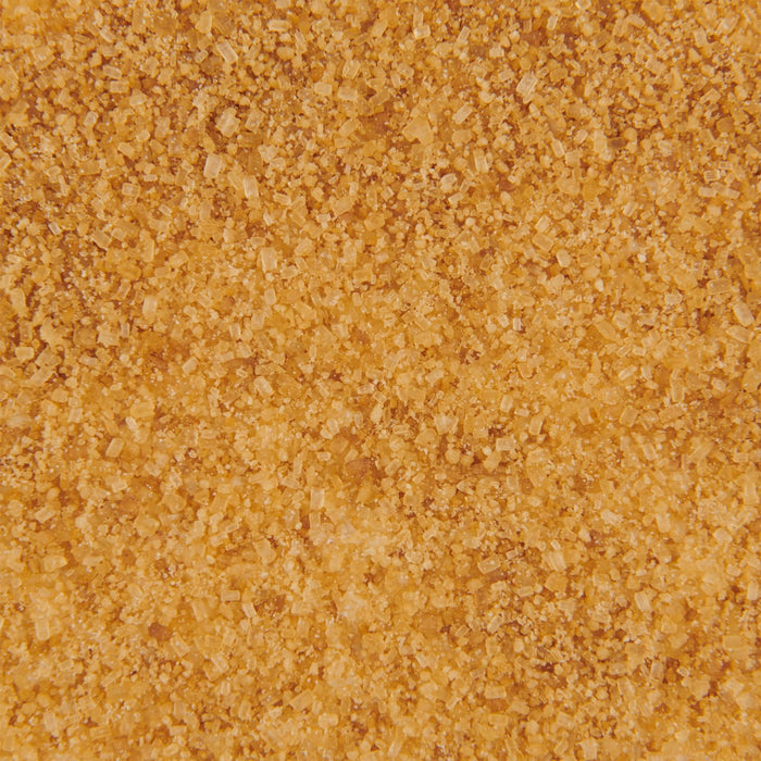 A close-up view of Mccormick English Toffee Finishing Sgr 3.7 Oz, showing a textured surface of light brown sugar crystals