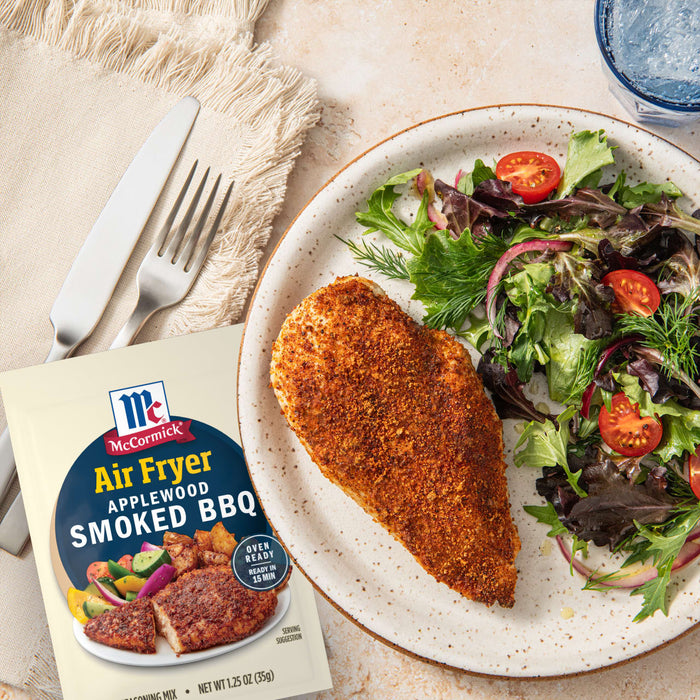 A plate with air fried chicken seasoned with McCormick Air Fryer Smoky BBQ seasoning, accompanied by a fresh salad.