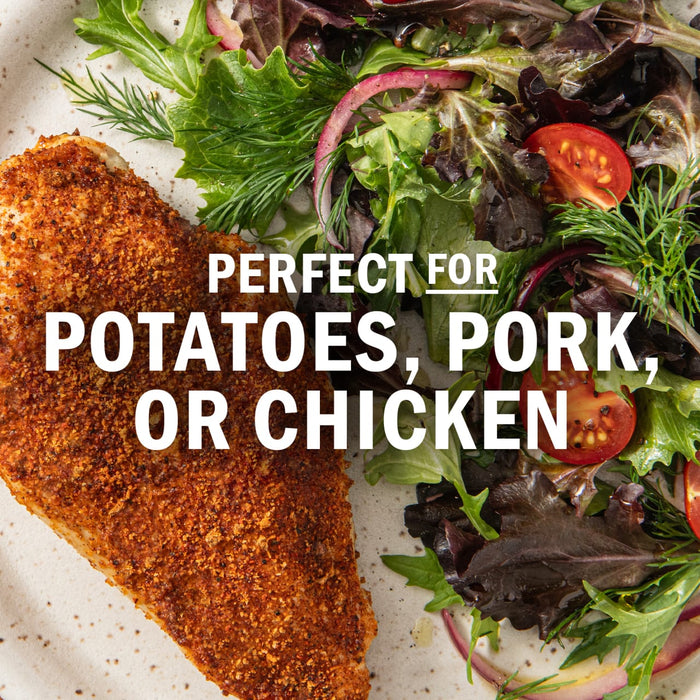 This image promotes a seasoning blend that is perfect for potatoes, pork, or chicken, as shown with a breaded cutlet and a fresh salad.