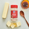 ['A jar of McCormick Brown Butter Seasoning with butter sticks and a bowl of melted butter.']