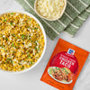 A bowl of taco rice with cheese and a packet of McCormick Street Style Chicken Taco seasoning.