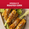 Roasted corn on a plate with lime wedges, suggesting a flavorful dish.