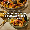 A delicious paella dish is showcased, highlighting its essential use for paella, risotto, bouillabaisse, and tagines.