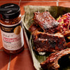 ['A jar of McCormick Culinary Tamarind &amp; Pasilla Chile Seasoning sits next to a plate of ribs.']