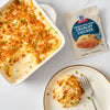 A creamy potato casserole topped with McCormick Crunchy Topping is served on a plate next to the baking dish and seasoning packet.