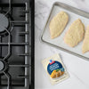 A packet of McCormick Shake n Bake Original Recipe Chicken is displayed next to breaded chicken cutlets on a baking sheet, ready to be cooked.