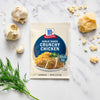 A packet of McCormick Garlic Ranch Crunchy Chicken mix is displayed with garlic, parmesan cheese, and dill sprigs.