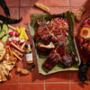 ['A plate of grilled ribs with a side of coleslaw and a bottle of McCormick Tamarind &amp; Pasilla Chili Seasoning.']
