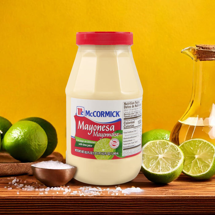 A bottle of McCormick Mayonesa with lime juice next to limes and salt on a wooden table.