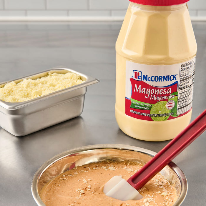 ['A jar of McCormick Mayonnaise next to a bowl of mayonnaise with a red spatula.']