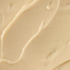 ['A close-up of a creamy, beige substance, possibly a lotion or moisturizer.']