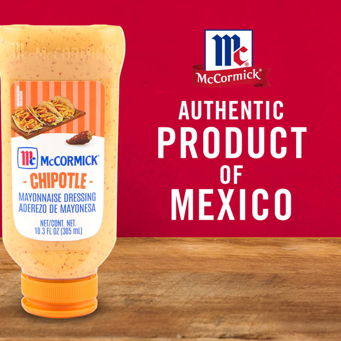 ['A bottle of McCormick Chipotle Mayonnaise Dressing on a wooden table with a red background.']