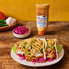 ['McCormick Chipotle Mayonnaise Dressing on fish tacos with avocado, red cabbage, and lime wedges.']