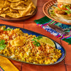 ['A plate of Mexican street corn with cotija cheese, chili powder, and lime.']