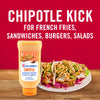 ['A bottle of McCormick Chipotle Mayonnaise Dressing next to a plate of fish tacos.']