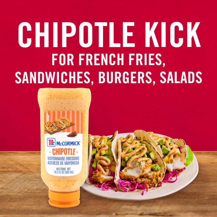 ['A bottle of McCormick Chipotle Mayonnaise Dressing next to a plate of fish tacos.']