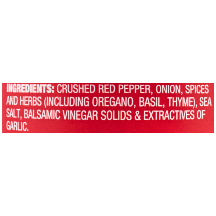 ['A red label with white text listing the ingredients for a crushed red pepper product.']