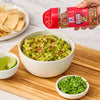 ['A bowl of guacamole topped with McCormick Red &amp; Green Pepper Blend.']