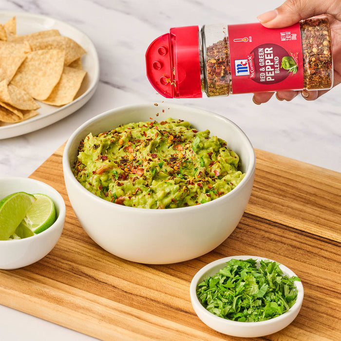 ['A bowl of guacamole topped with McCormick Red &amp; Green Pepper Blend.']
