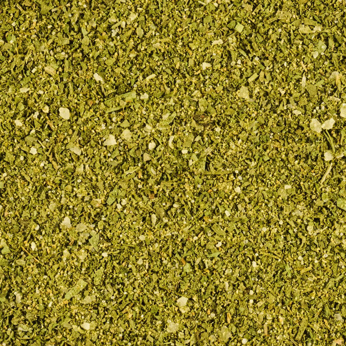 ['A close-up shot reveals a vibrant green mixture of dried herbs and spices, creating a textured and aromatic visual.']