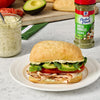Sandwich with avocado, tomato, and lettuce on a plate with McElroy Perfect Pinch Green Goddess seasoning.