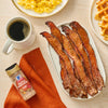 A breakfast spread featuring McCormick Maple Seasoning, bacon, eggs, waffles, and coffee.